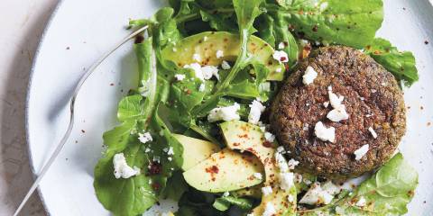 Lentil and Chard Cakes on white plate garnished with avocado.