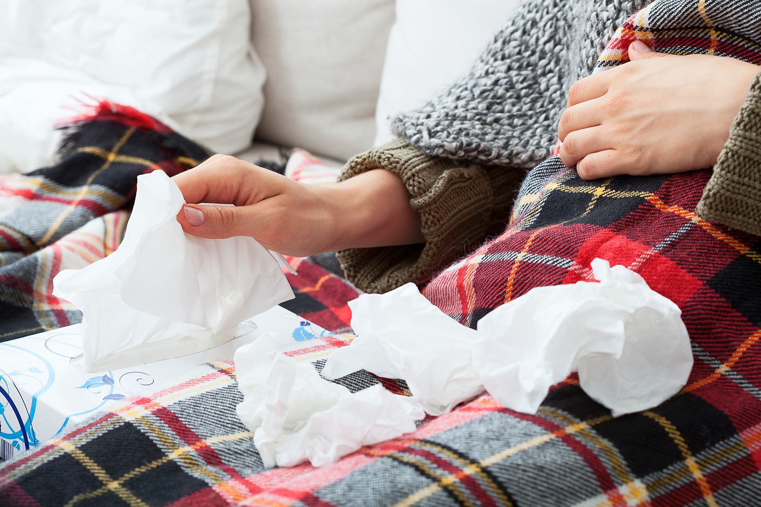 a woman with a pile of used tissues