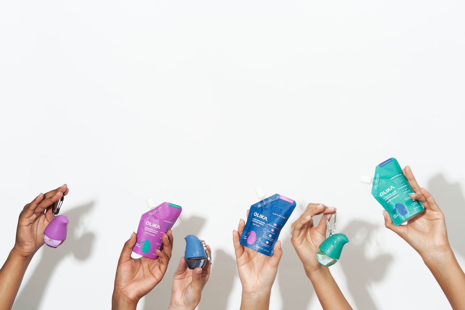 people holding containers of hand sanitizer