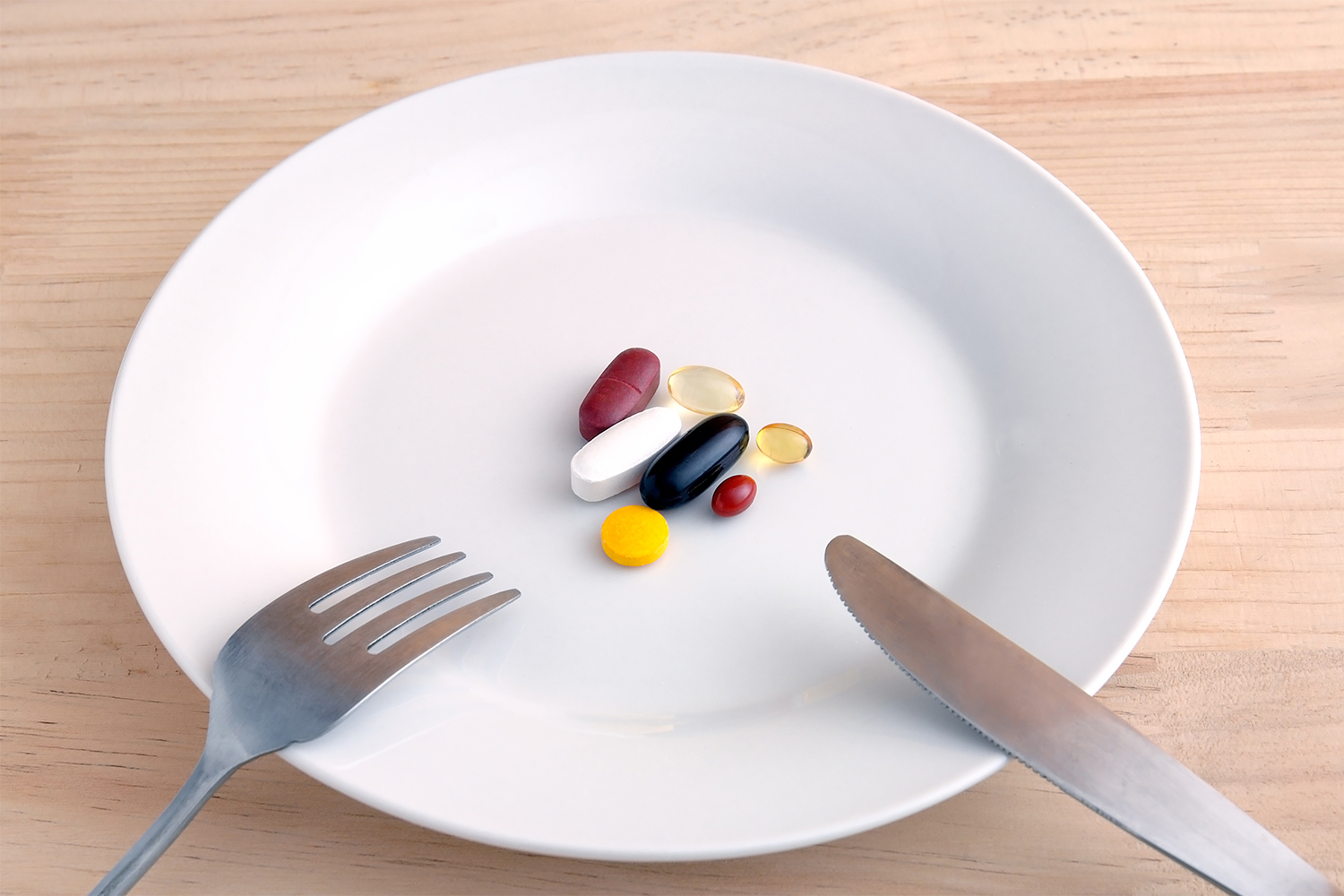 a fork and knife on a plate with dietary supplements