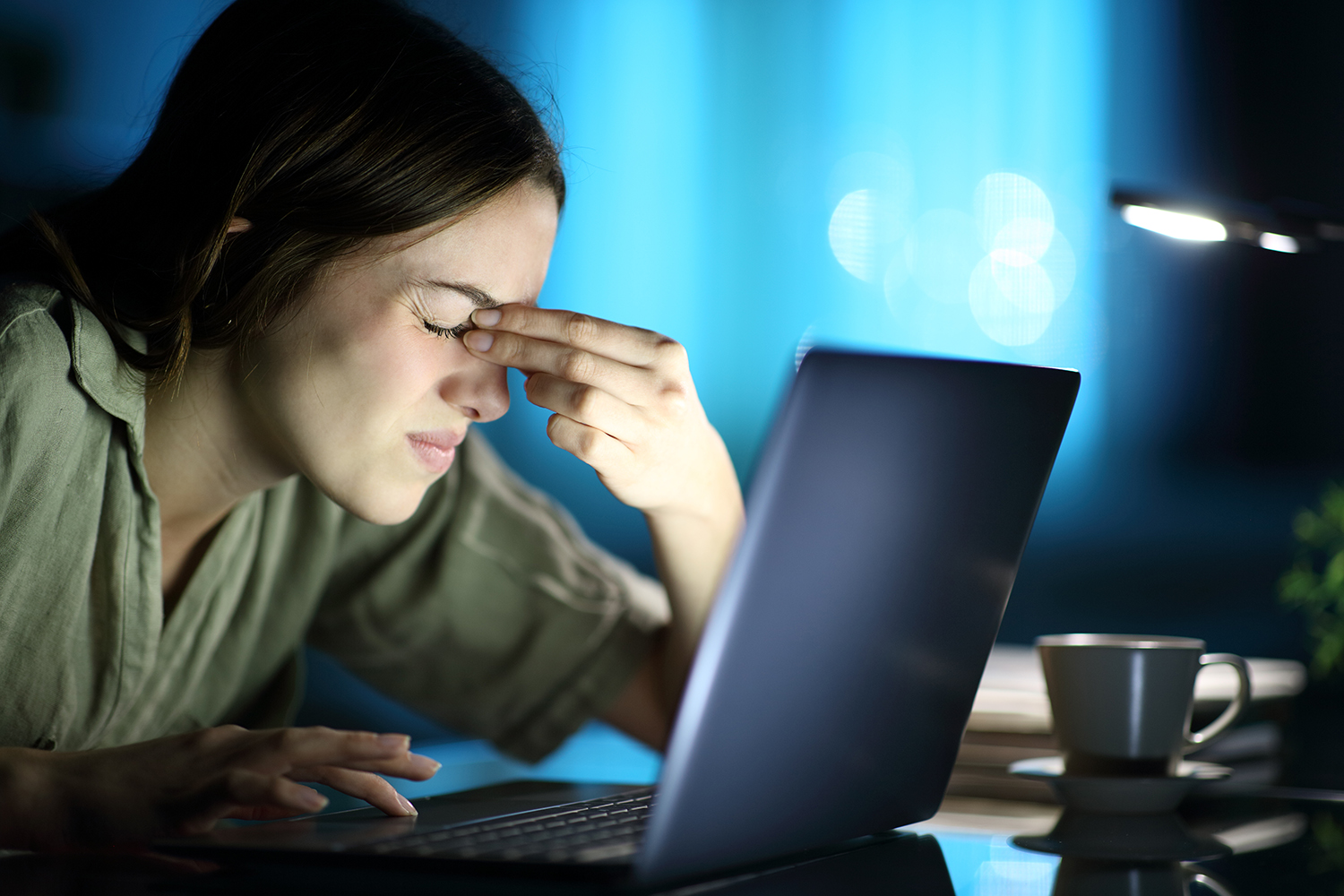 a woman straining her eyes at night looking at a screen