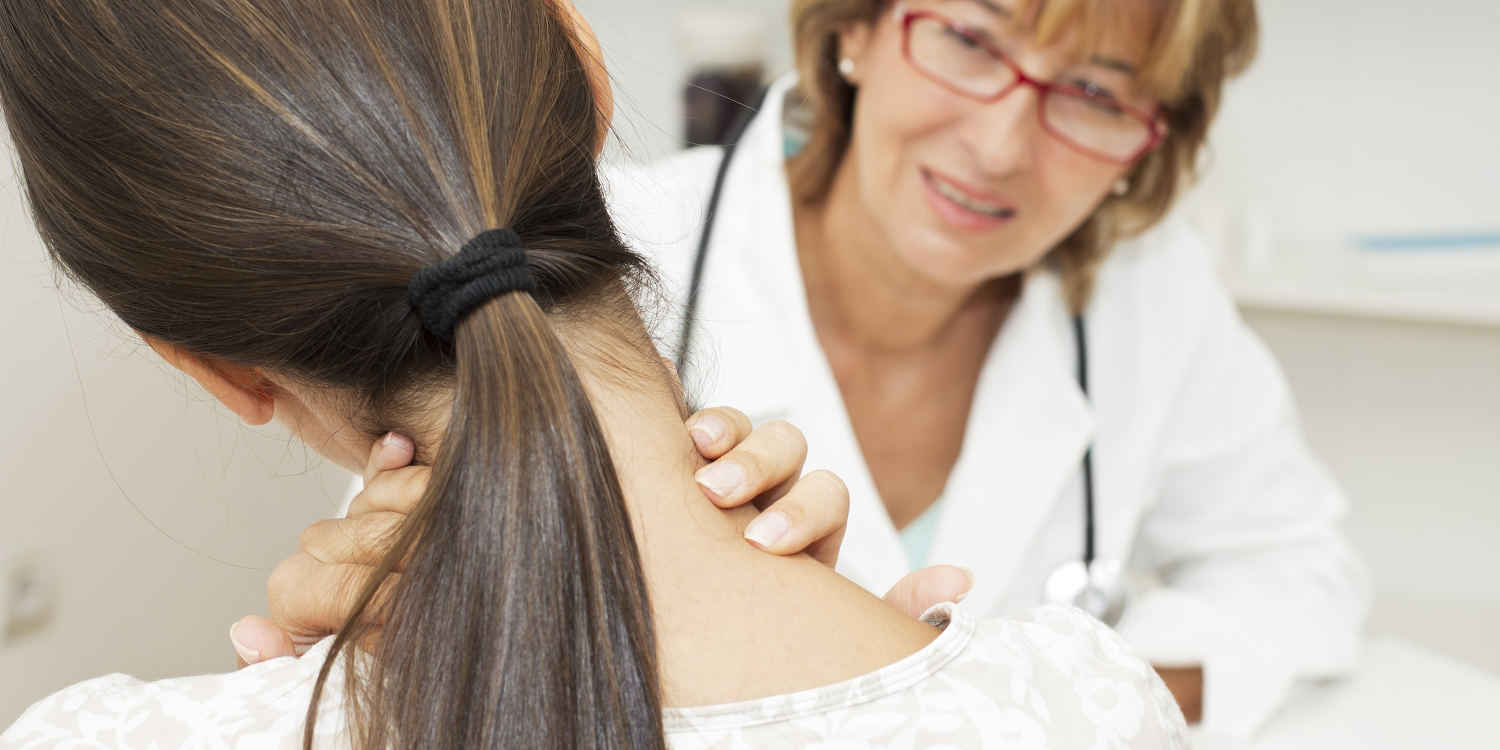 A doctor inspecting a woman who has a kink in her neck