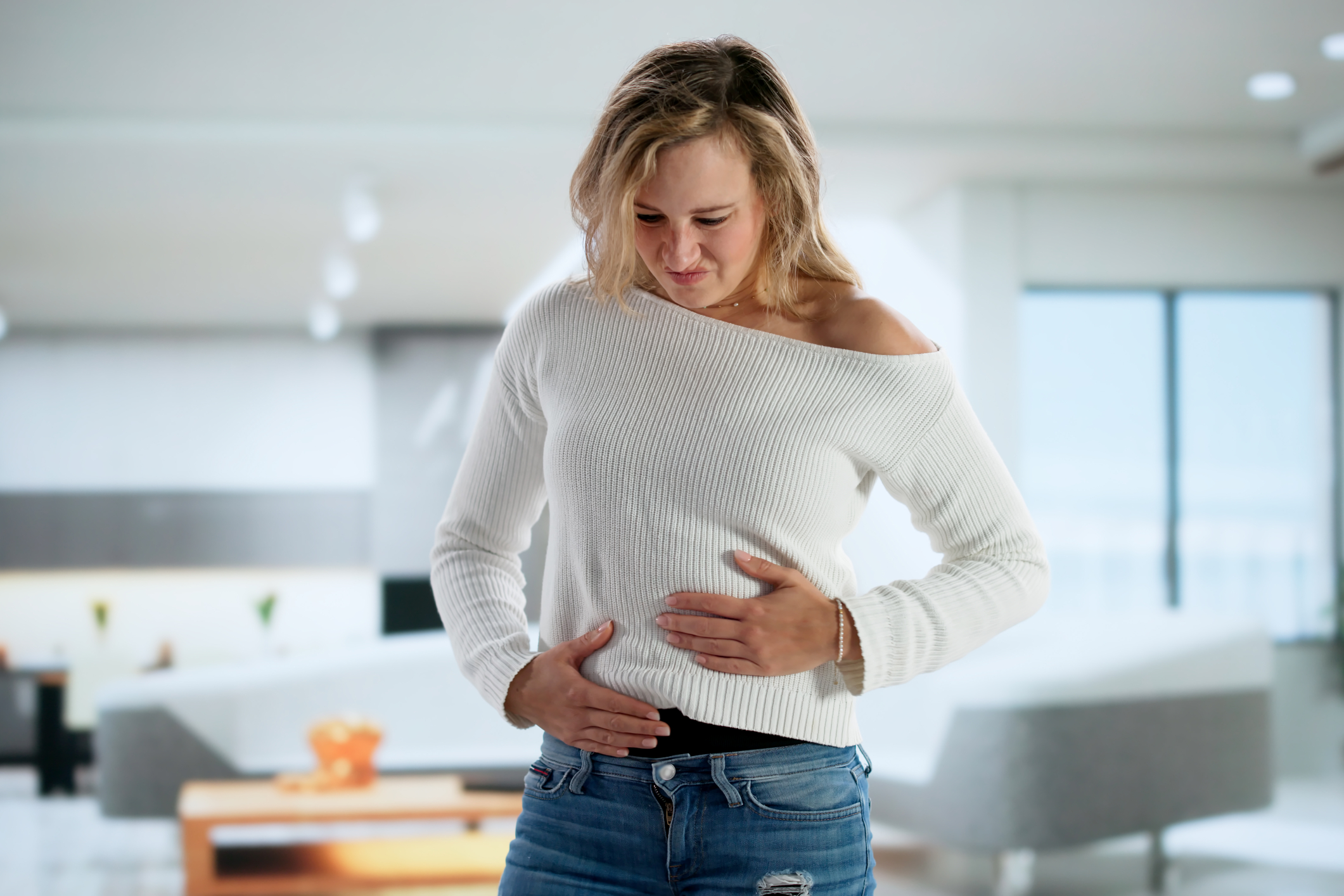 Woman holding both sides of her guts.