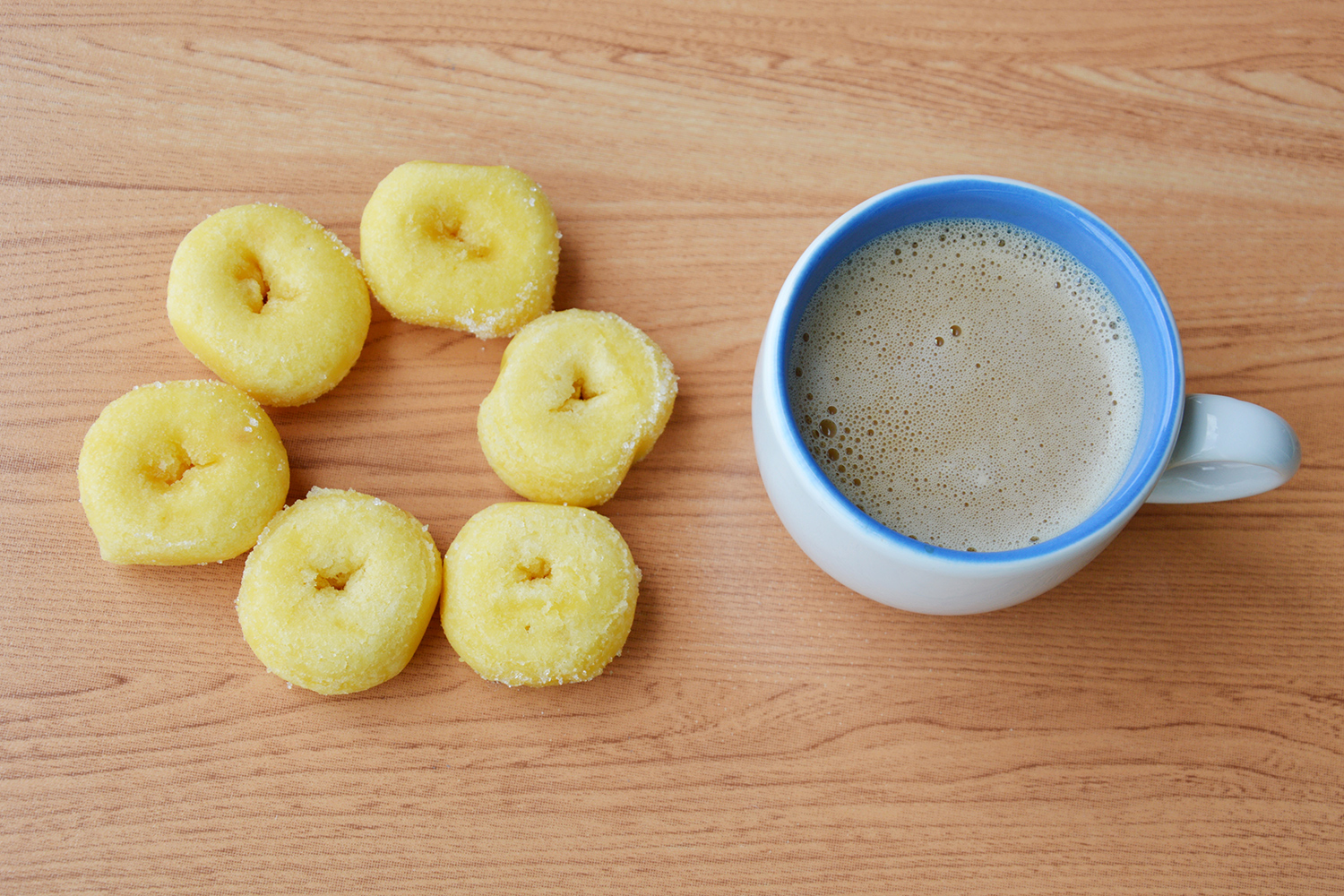 Miniature donuts next to a cup of coffee