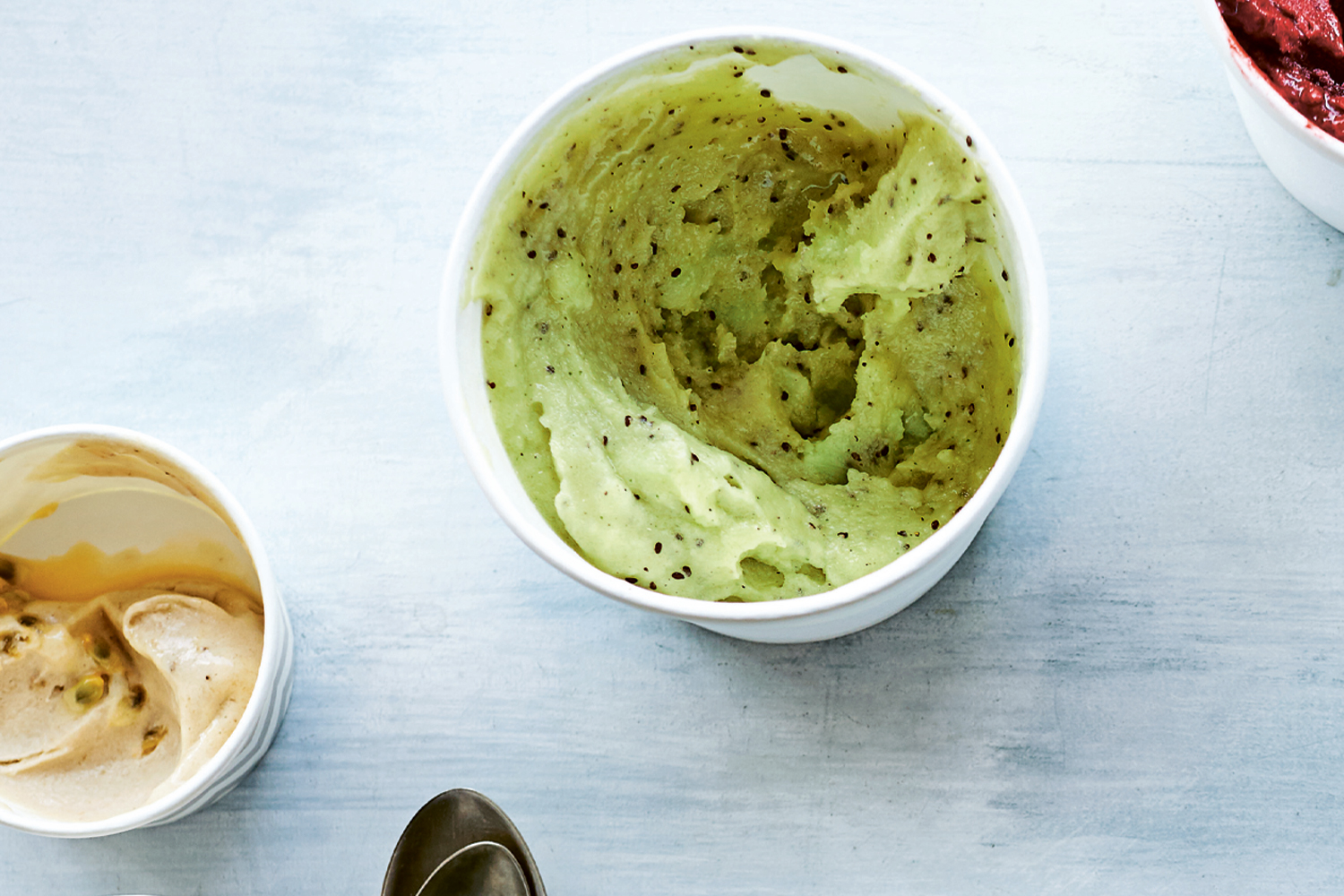 a cup of smooth light green sorbet with seeds