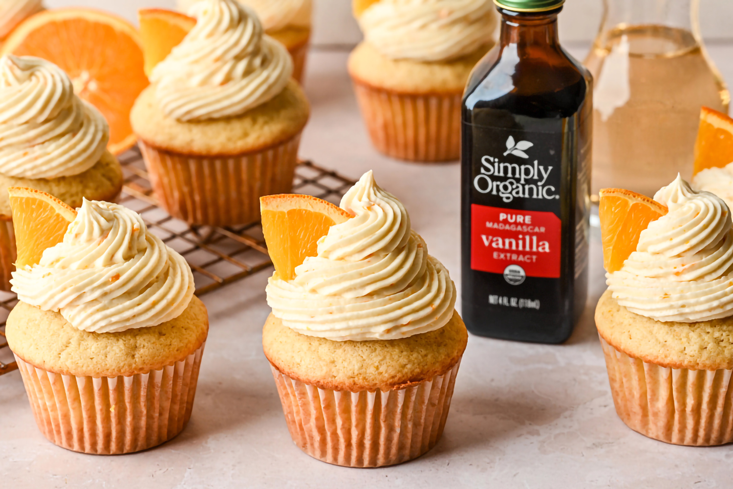 a batch of mimosa cupcakes and a bottle of vanilla extract