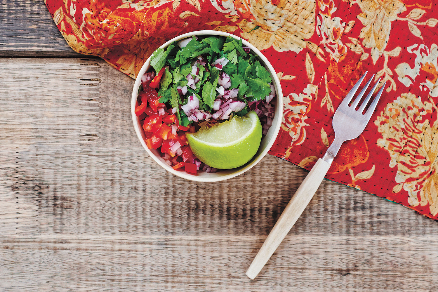 a bowl of salsa on a picnic table
