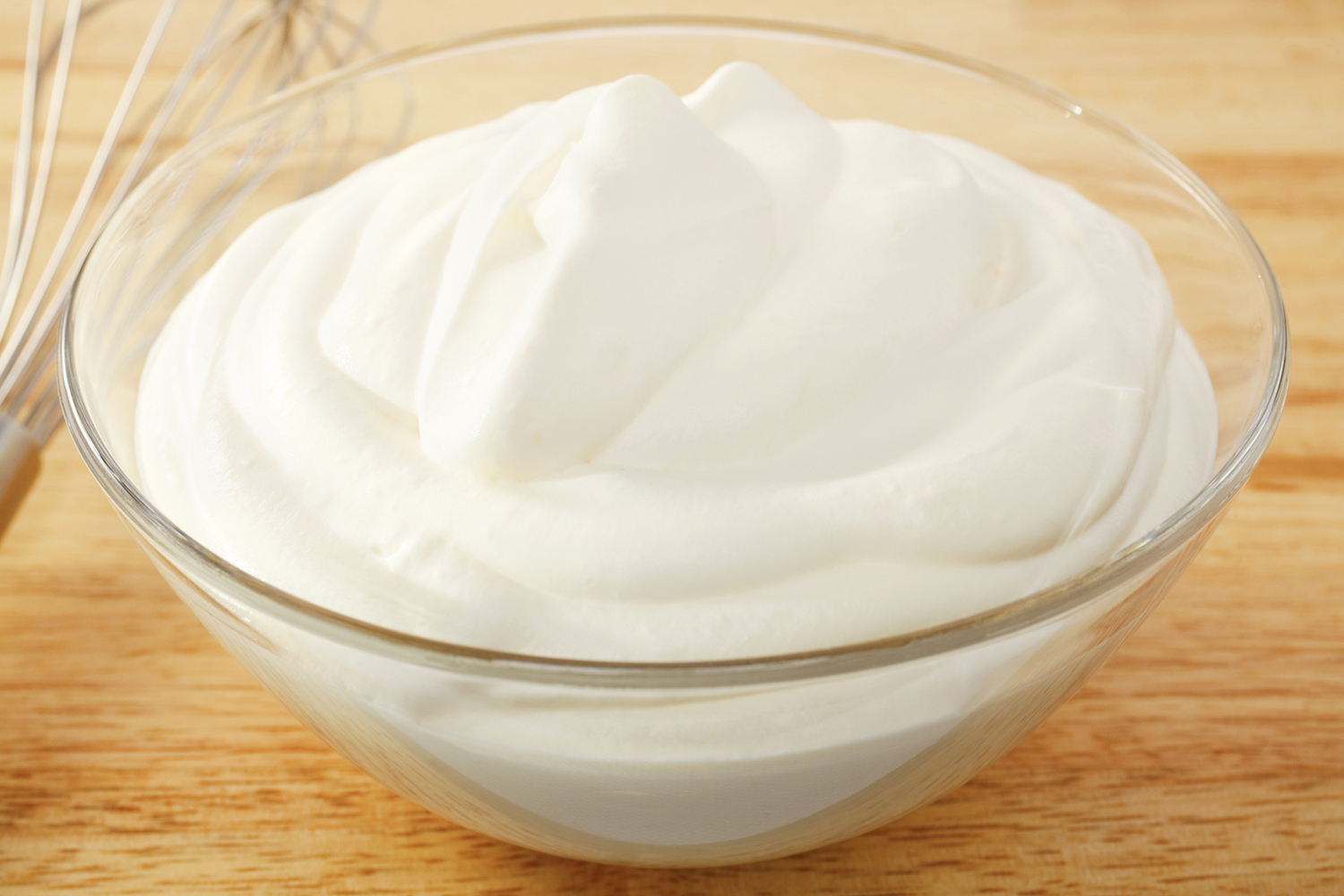 a dish of whipped cream and a whisk
