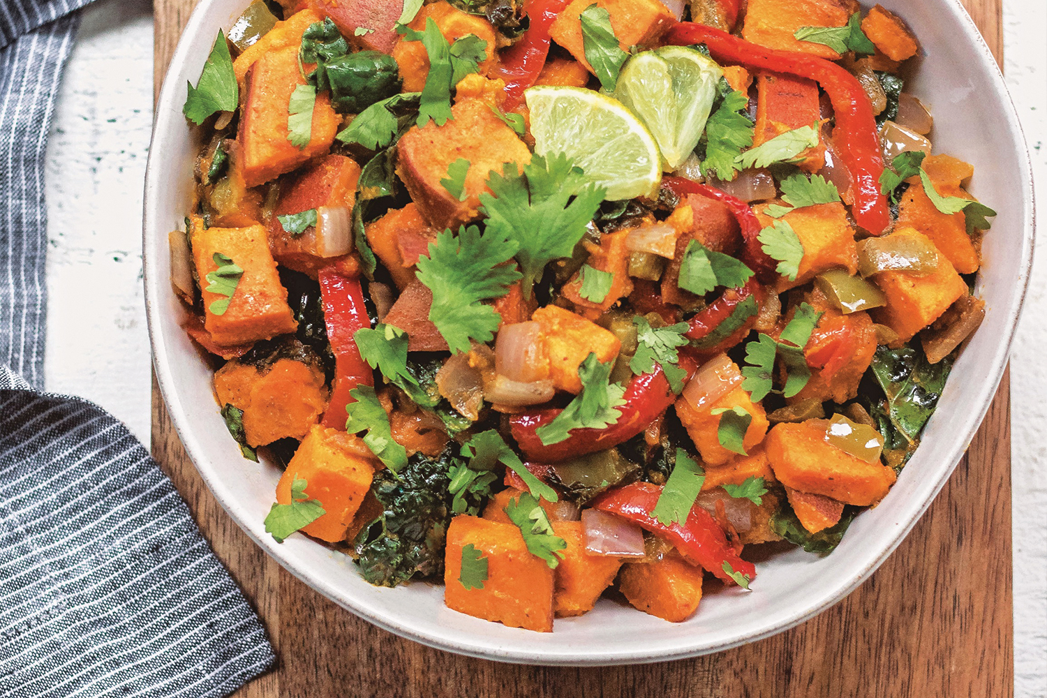 Top view of Chipotle-Sweet Potato Salad in a white bowl on a wooden table.