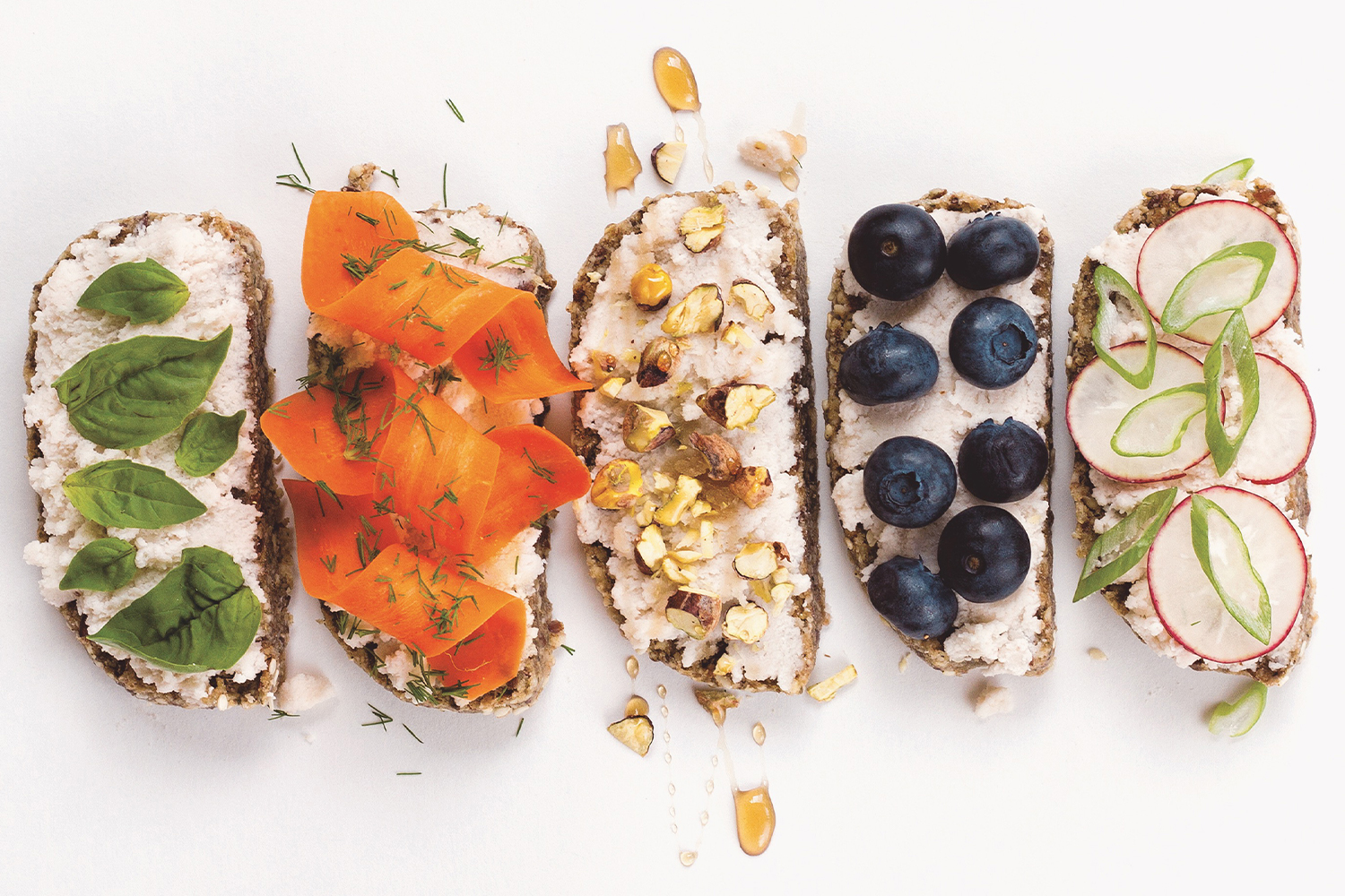 Almond Ricotta on five slices of bread with different toppings in a row.
