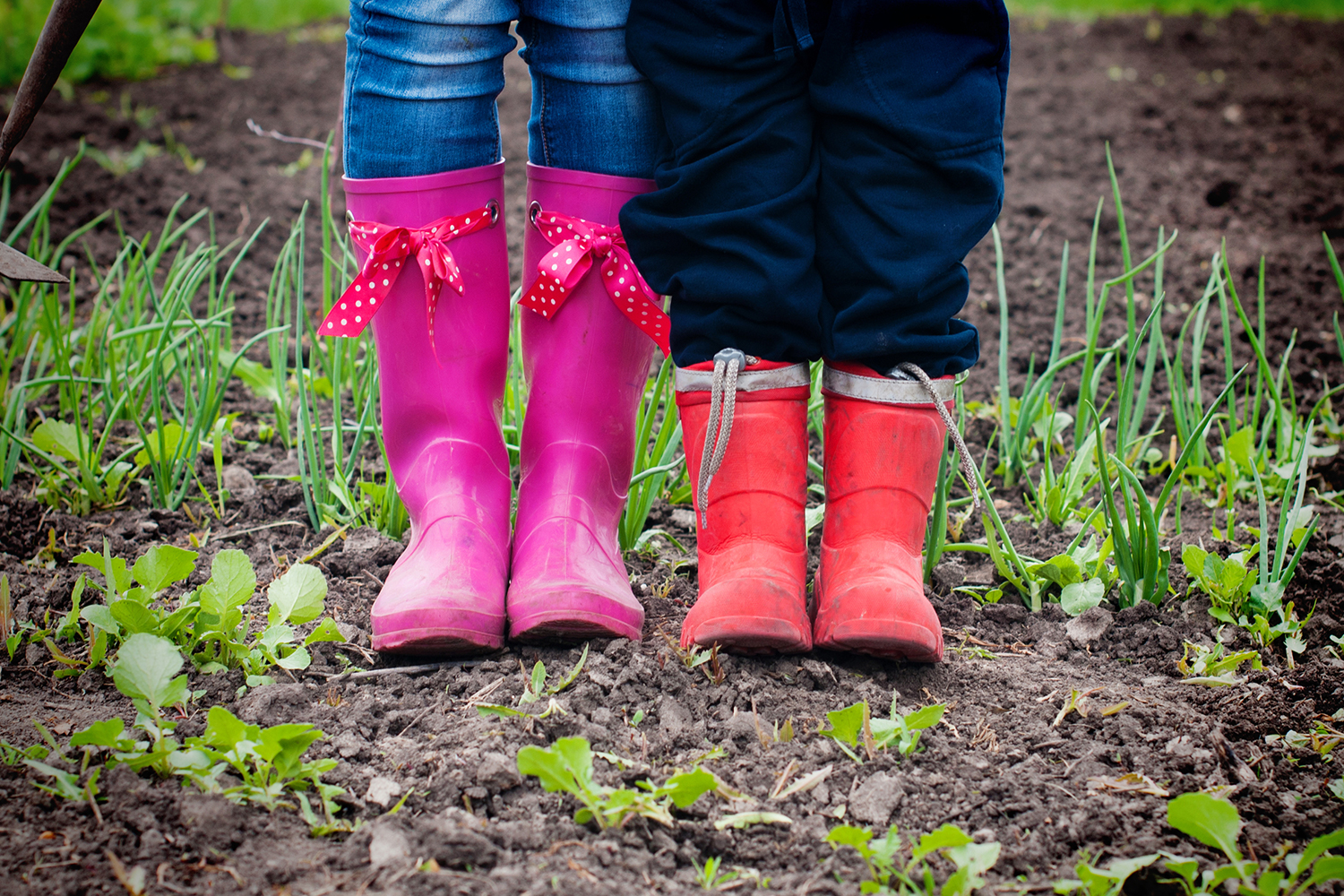 View of rubber boots, woman and child in a garden