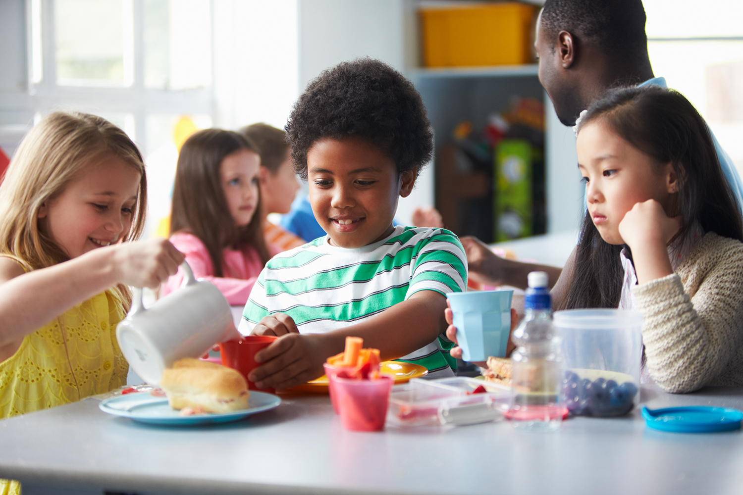 a group of schoolchildren eating lunch together