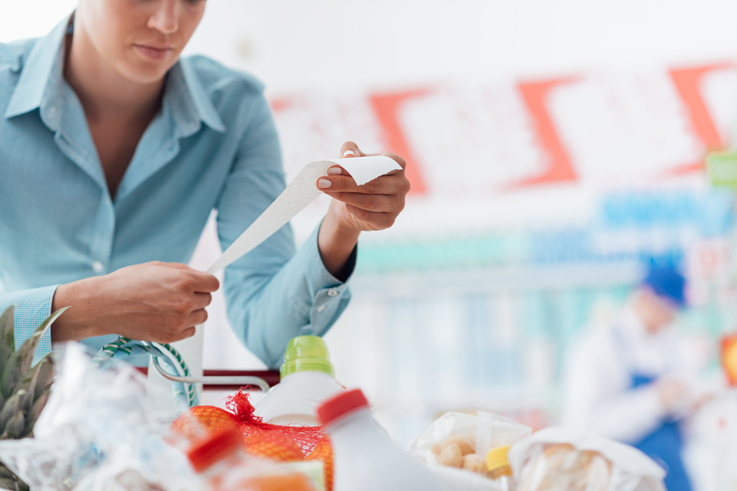 a woman holding a long receipt from the grocery store