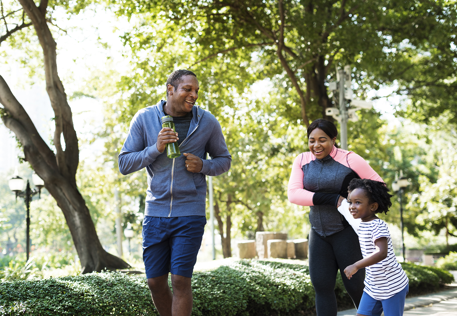 Family enjoying outdoor activity and jogging through a park.