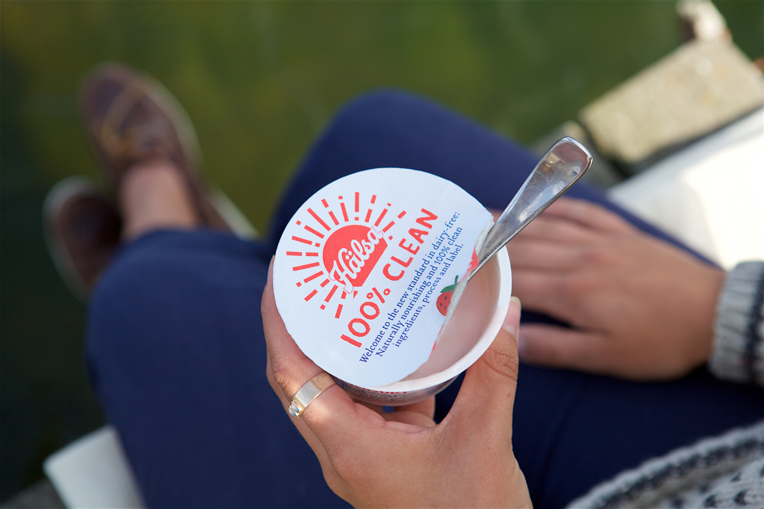 a woman eating yogurt with that claims to be 100% clean