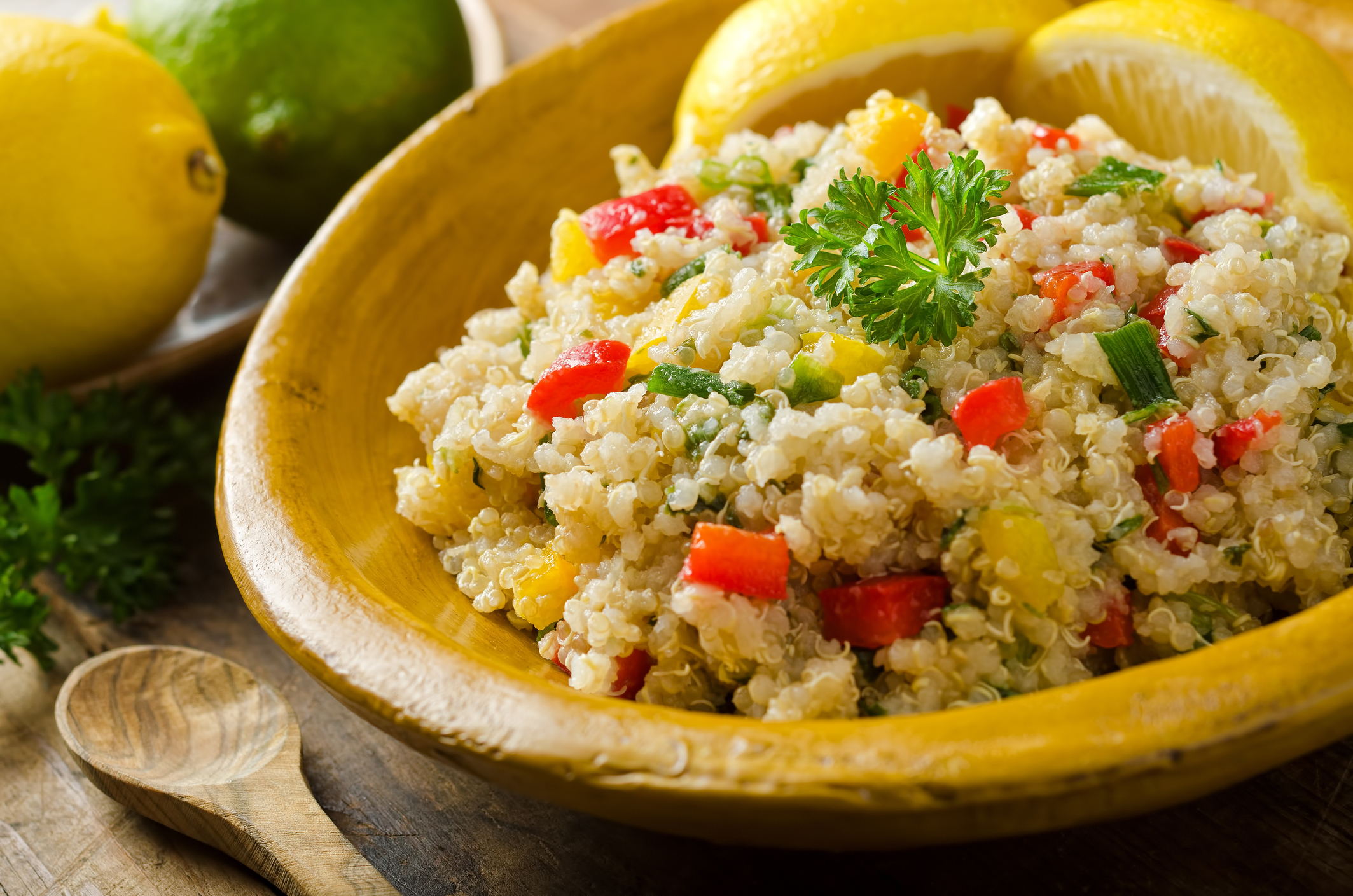 Bowl of quinoa salad with corn and chopped red pepper.