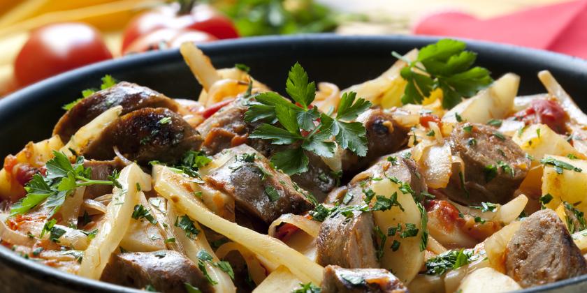 a dish of casserole with sausage, noodles, and green veggies