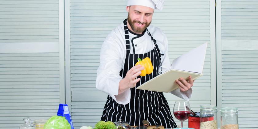 a cook reading kitchen tips from a guidebook