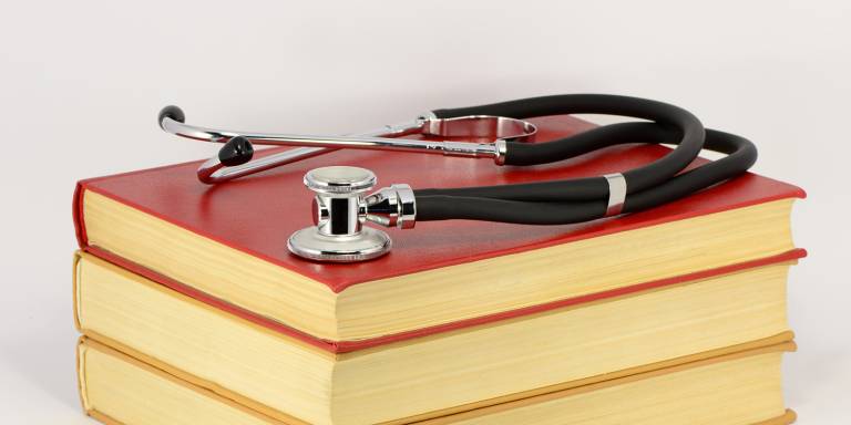 a stack of medical books with a stethoscope
