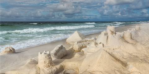 sand castles with waves approaching swiftly