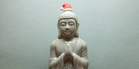 a statue of Siddhartha wearing a Santa hat