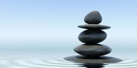 zen standing stones balanced in rippling water