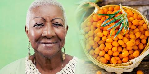 mature african american woman and a basket of sea buckthorn berries