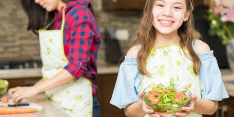 A girl holding a fresh made salad.