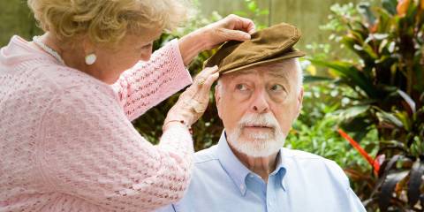 A senior woman putting a hat on her husband