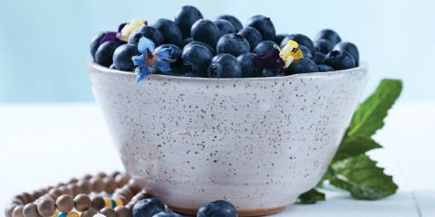A bowl of blueberries and some Buddhist prayer beads