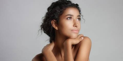 Happy serene young woman with beautiful olive skin.