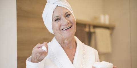 an older woman applying cream