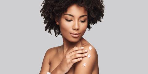 a woman with beautiful skin applying moisturizer