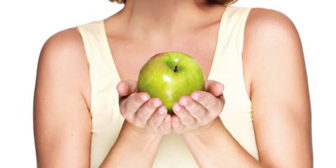 A woman with healthy skin holding an apple