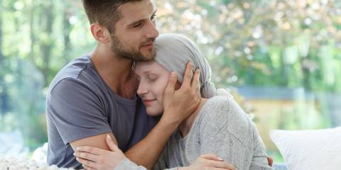 a woman with cancer being held by her partner