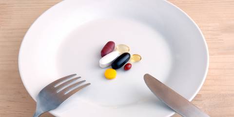 a fork and knife on a plate with dietary supplements
