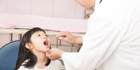 Doctor checking patients throat
