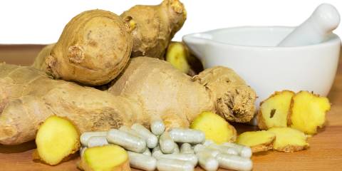 Ginger root accompanied by a motor and pestal with supplements capsules.