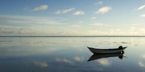 a small boat floating in still and empty waters