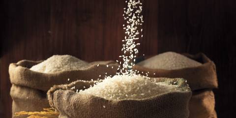 White rice being poured into burlap sacks