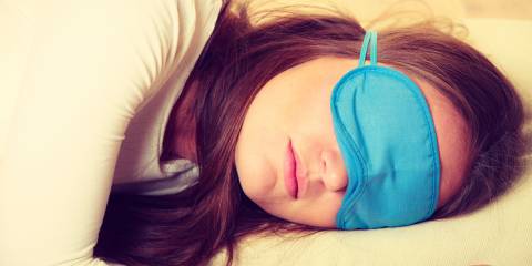 Portrait of brunette woman sleeping in blue eye mask