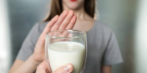 a young woman refusing a glass of milk