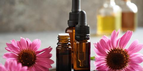 3 small amber bottles surrounded by purple echinacea blossoms