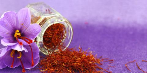 A small glass bottle on its side with saffron spilling out.