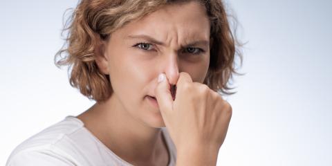 Woman holding her nose.