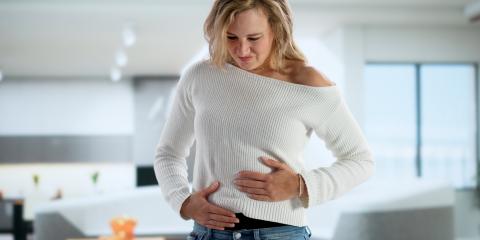 Woman holding both sides of her guts.