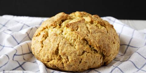 Butternut squash soda bread cooling on a white and blue tea towel.