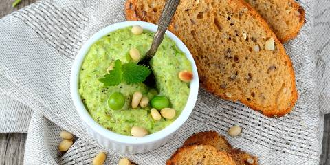 a bowl of pea dip and some toasted bread