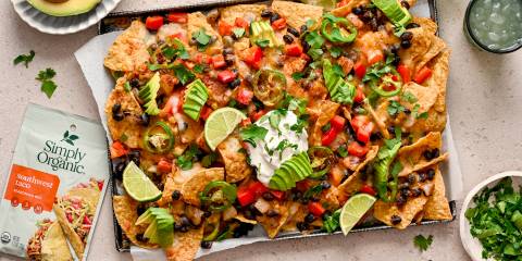 a large plate of tortilla chips with beans, cheese, and avocado