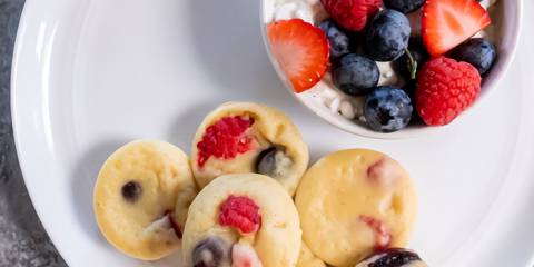 a plate of pancake bites with cottage cheese and berries